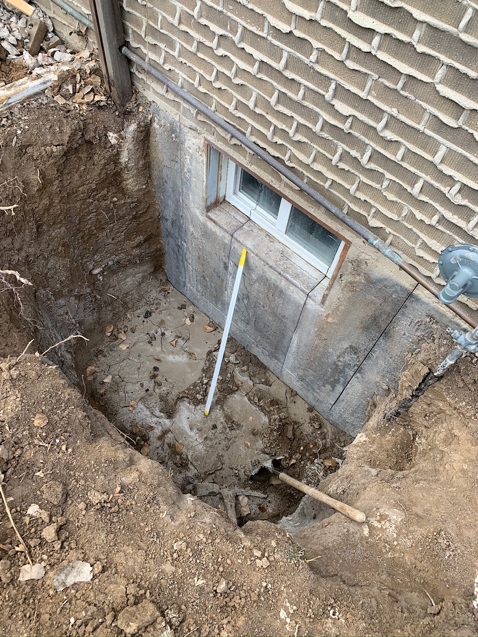 Excavation area opened near the structure for prep and access documentation.